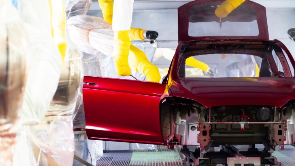 A Tesla being sprayed red at the company's Freemont, California facility.