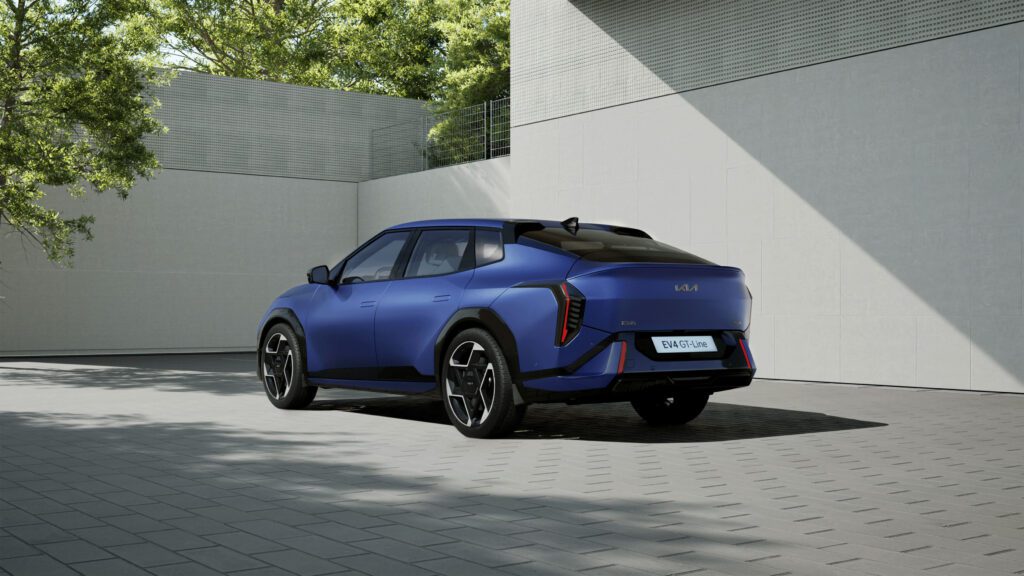 A Kia EV4 parked in a driveway, painted in a dark blue colour.